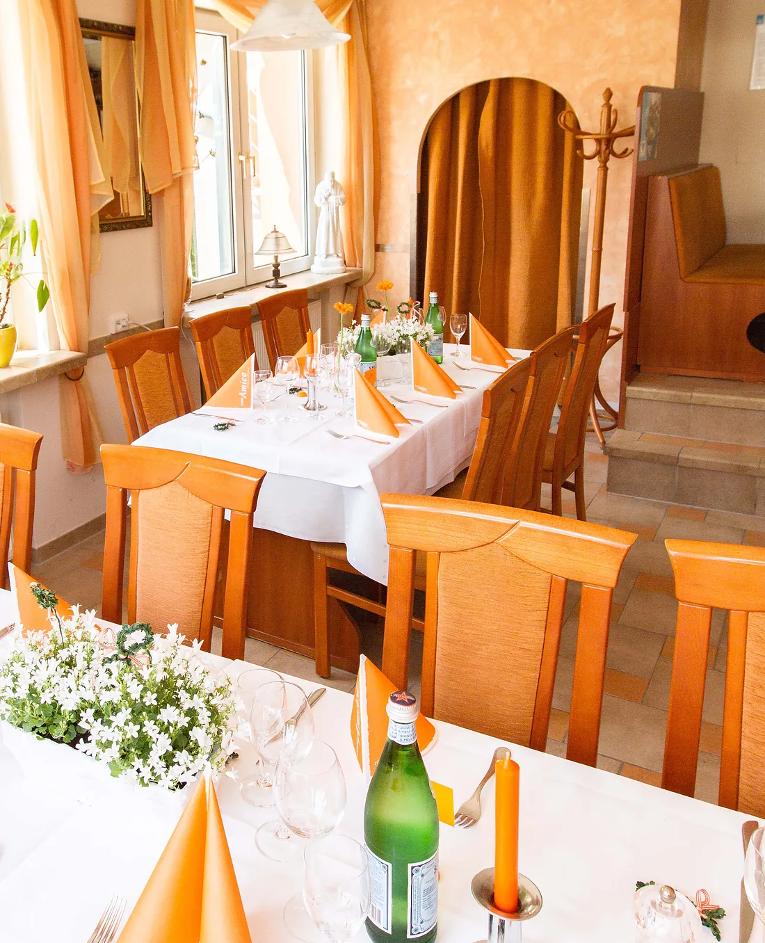 Eingedeckter Tisch mit weißer Decke, gefalteten Servietten und weißen Blumen